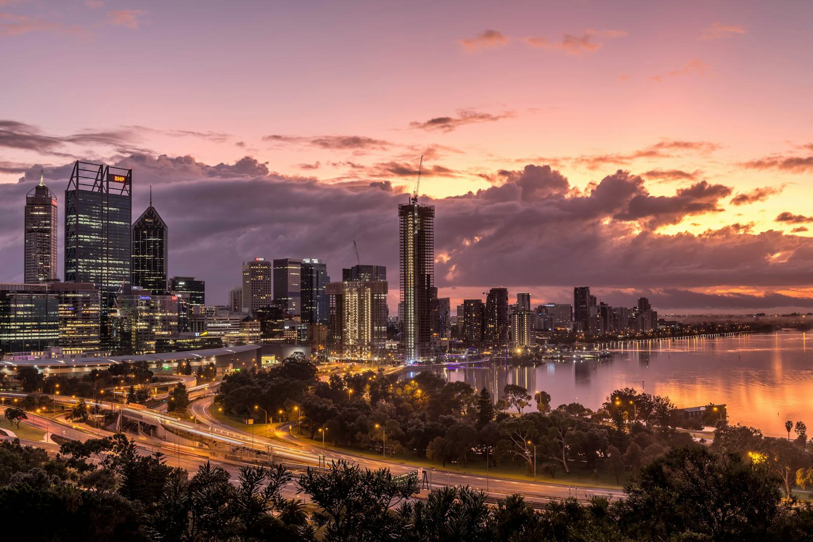 A city and river under a pink sunset sky